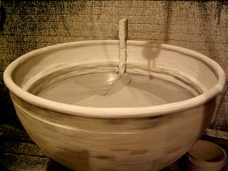 The ceramic shell tank Image of large "dip" tank full of silicon polymer for building up the ceramic shell around the wax original. Image shows tank in motion to keep polymer from solidifying when not being used.